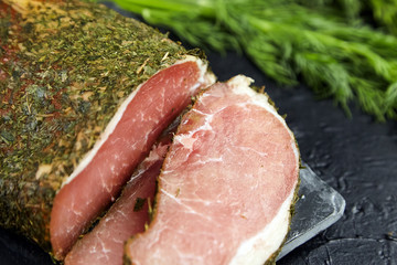 Polendwitz is a jerky tenderloin, dried pork with spices and fresh green dill, slate cutting board on black stone table