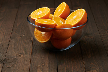 Fresh orange fruits whole and sliced on a wooden table - natural and healthy food.