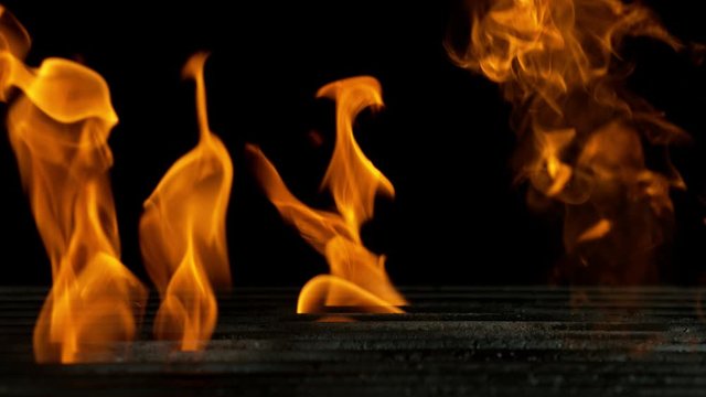 Super slow motion of empty grill grid with fire on black background. Filmed on high speed cinema camera, 1000 fps
