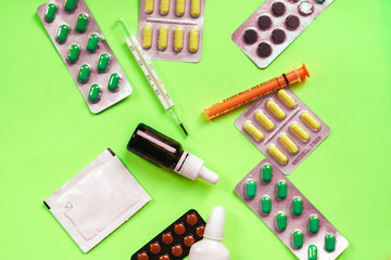 Pills and thermometer on a green background, pills in blister packs, medicine and health, concept of Corona virus quarantine, Covid-19