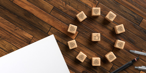 cube with icons symbolizing a meeting and office items on wooden background