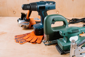 Electric building and crafting instruments and tools on the wooden background