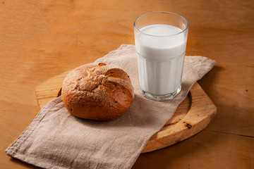 Glass of milk and homemade bread on the wooden table. with copy space for text