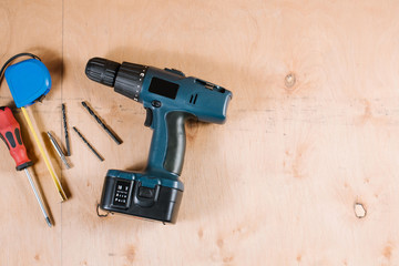 A screwdriver with other crafting tools on the wooden background