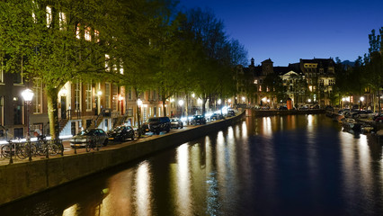 Fototapeta premium Night view of buildings along a canal in Amsterdam.