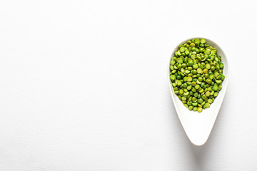 Green peas, beautifully laid out on a white background. in a cup. Top view. copy space.. Vegetarian food.