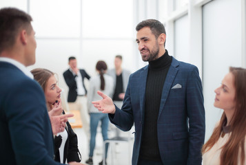 young employees discussing their ideas standing in the office