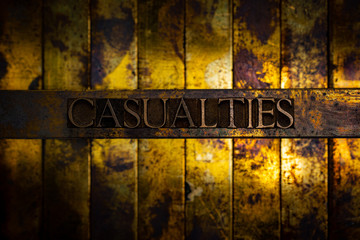 Photo of real authentic typeset letters forming Casualties text on vintage textured grunge copper...