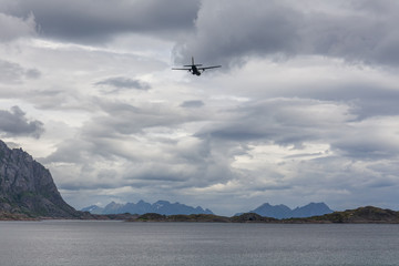 airplane flying in the cloudy sky of the Norwegian fjords, Lofoten