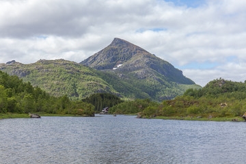 Beautiful view of the Norwegian fjords with turquoise water surrounded by cloudy sky, selective focus