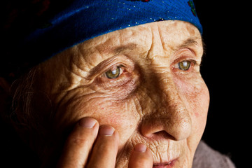 Caring for elderly parents. Old grandmother with clean eyes close-up. The face of an aged mother looks forward with hope. Values of parents are not eternal. Care for the elderly. Do not leave old