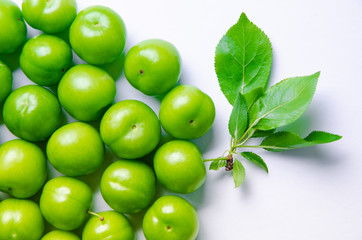 green plums on white ground