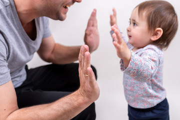 Good father clapping hands with his daughter on Father's Day holiday. Friendship with parent and kid