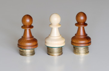 Three pawns chess pieces on columns of coins, symbolizing the equality of income - 346291736