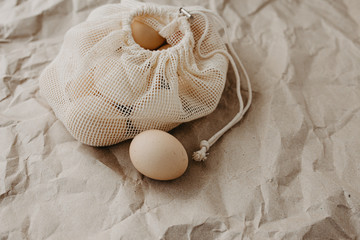 Fototapeta na wymiar Farm eggs in eco natural bag on craft paper background.