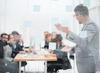 head of the project, pointing to the sticky notes during a work meeting