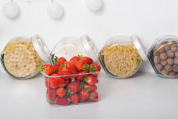 Fresh Organic Strawberries In A Plastic Box In The Kitchen. delivery of organic products. packaging of organic strawberries.