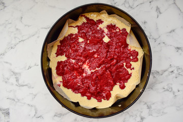 Dough with berries, in a baking tray