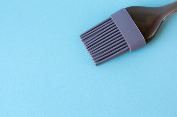 Silicone brush with transparent handle on blue, isolate, copy space.