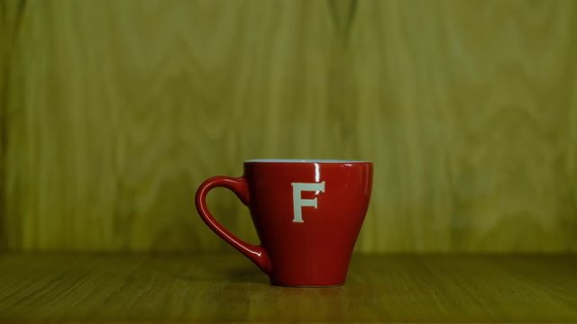 small red coffee cup on a wooden tabletop