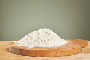 Flour over wooden cutting board. Close up