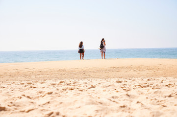 Two girls friends on relaxing on the beach at Norte beachm Nazaré