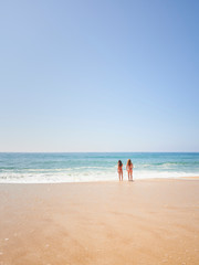 Two girls friends on relaxing on the beach at Norte beachm Nazaré