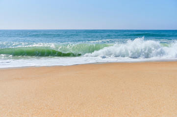 atlantic green waves crashing on the beach at north beach, Nazaré