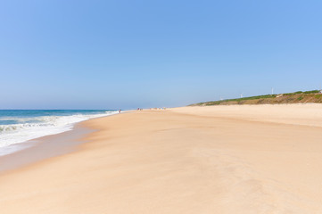 Long sandy beach on a sunny day at Nazaré norte beach