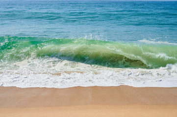 Fototapeta na wymiar atlantic green waves crashing on the beach at north beach, Nazaré