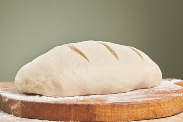 Fresh dough ready for baking bread on cutting board. Close up