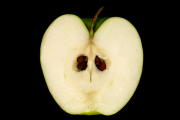 Cut green Apple with pits and peduncle on black background