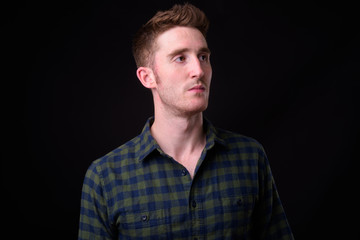 Face of young handsome hipster man thinking