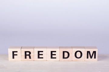 wooden cubes building the word Freedom, white background