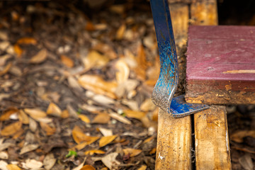 Flat pry bar lifting of a rotten plank off a deck construction