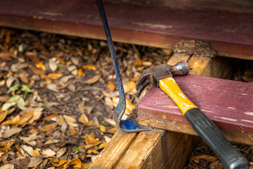 Flat pry bar and a claw hammer on a deck construction