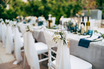 Wedding dinner table reception. White chair Chiavari Tiffany decorated with white delicate fabric...