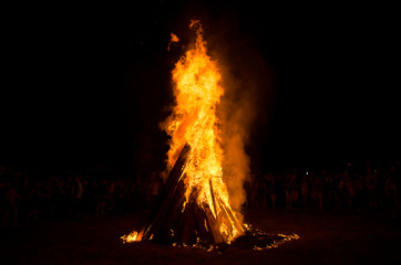 Huge bonfire at night. The Slavic holiday of Ivan Kupala. Round dance around the fire