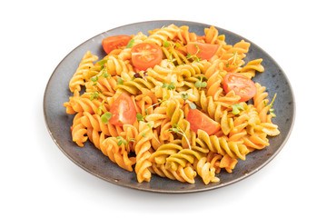 Tortiglioni semolina pasta with tomato and microgreen sprouts isolated on white background. Side view.
