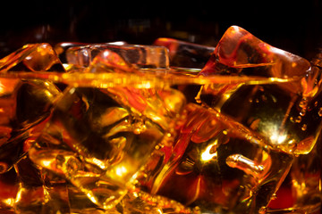 Ice in a glass of whiskey close up