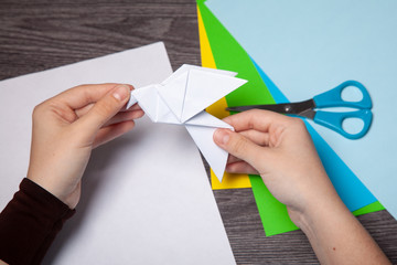 teenager hands make origami bird figure