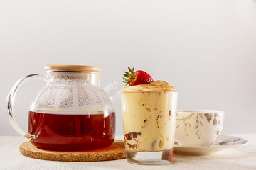 Tiramisu in a glass Cup, glass teapot and Cup and saucer