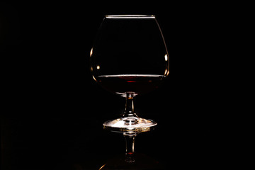 Glass with cognac on a black background