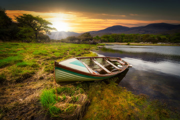 Beautiful scenery of the Killarney lake with boat at sunset in county Kerry, Ireland