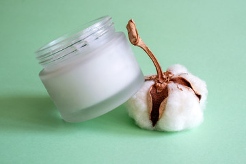 Glass container for cosmetics isolated on a green background. Free of plastic. Beauty concept.