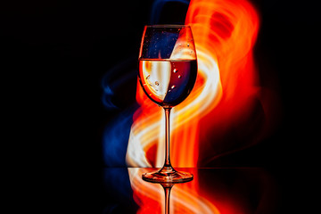 Glass for wine against the backdrop of bright color solutions 
