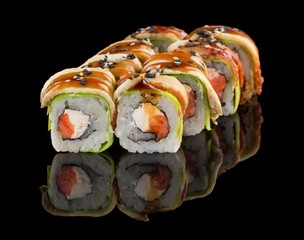 Sushi roll with salmon, cheese, avocado, eel, unagi sauce and sesame isolated on black background with reflection