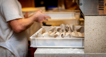 French baker making bread with a tray of baguettes ready to be baked