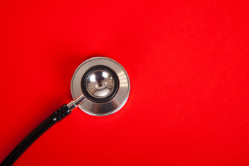 Stethoscope on red background