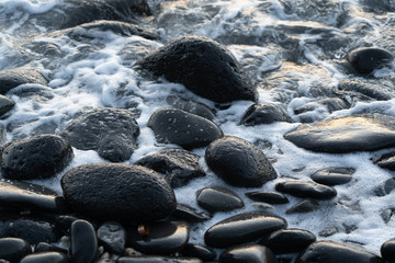 Sea foam on Black rocks